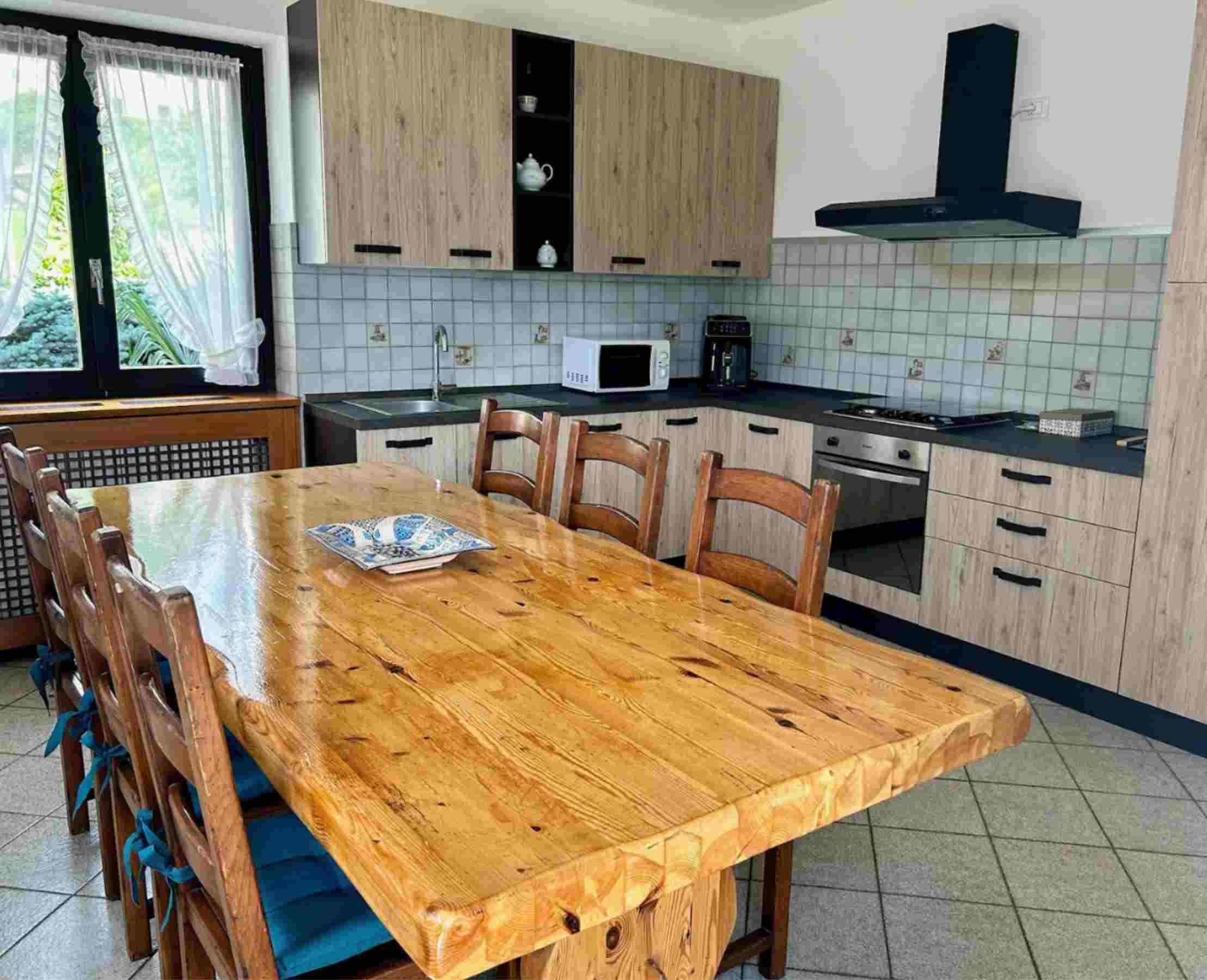 Cucina attrezzata con grande tavolo in legno a Bianzone in Valtellina.