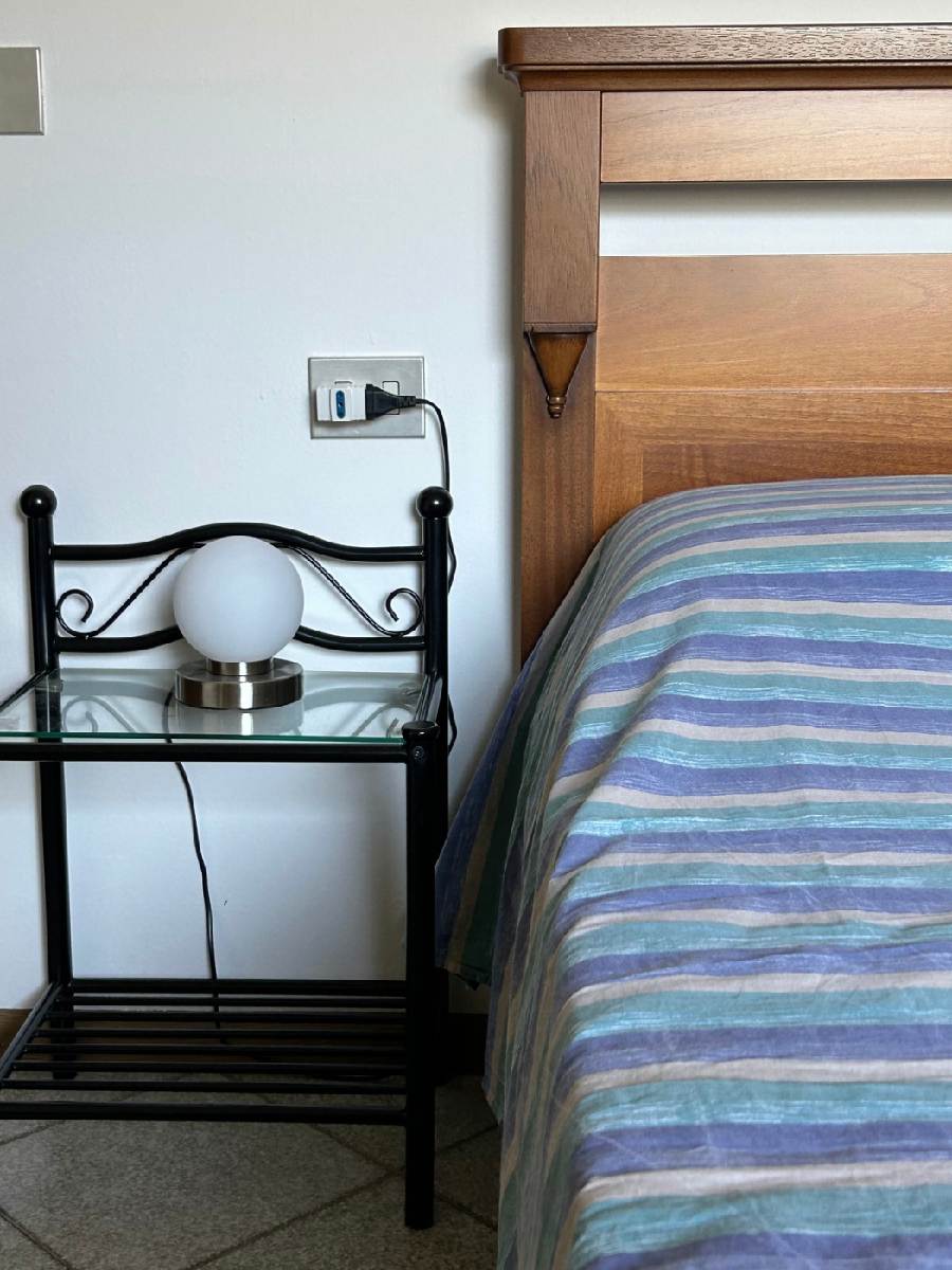 Comodino e porzione di letto matrimoniale