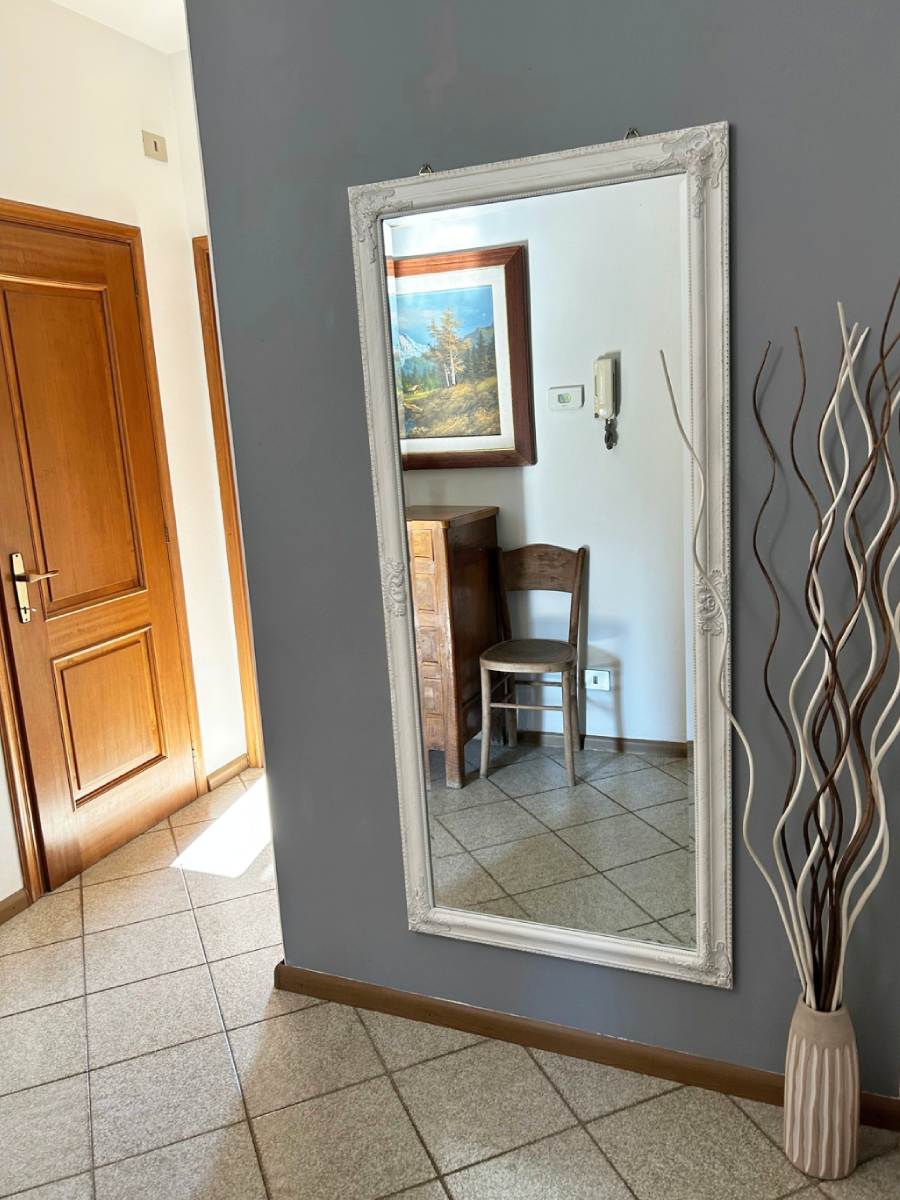 Specchio che riflette mobili d'epoca all'entrata di Valtellinda